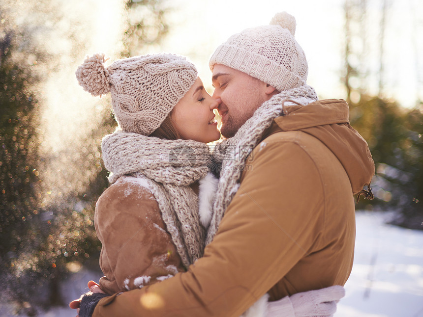 穿着冬装的年轻多情的侣要去接吻图片