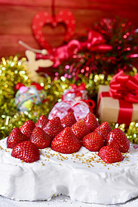 盛满奶油和草莓的圣诞蛋糕放在一张满了圣诞礼物和装图片
