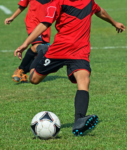 年轻足球运动员踢球图片