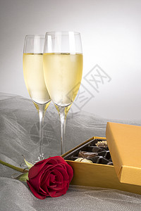 两杯香槟配一单红玫瑰和一盒巧克力准备迎接背景图片