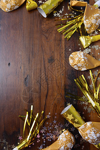 深色木桌背景上的金色新年派对装饰品图片