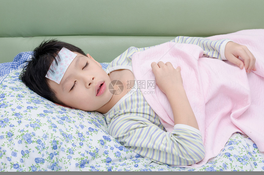 躺在床上的生病的小男孩图片