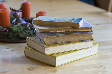 古老的硬皮书堆在生锈木板桌边背景图片