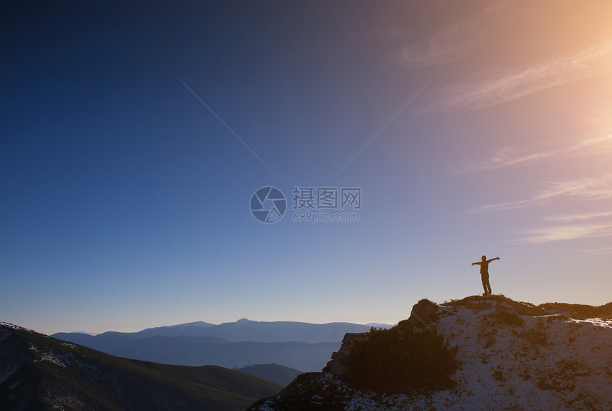 山上一个人对着蓝天的背影图片