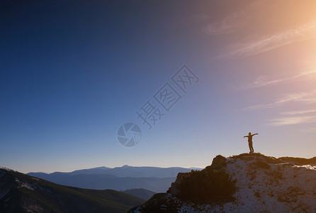 山上一个人对着蓝天的背影图片