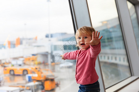 快乐可爱的小女孩在机场旅行图片