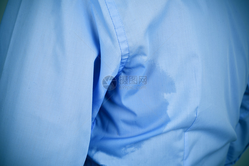 一个穿着蓝色衬衫身上有下臂汗渍的图片