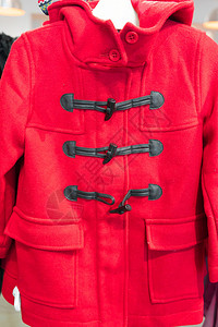 在服装店中显示红色彩Duffle外套的Man图片