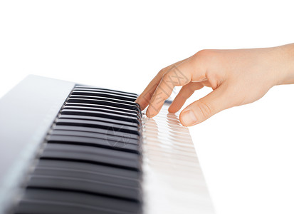 白色背景上的手和钢琴键盘图片