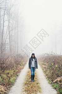 在迷雾森林中散步的女人图片