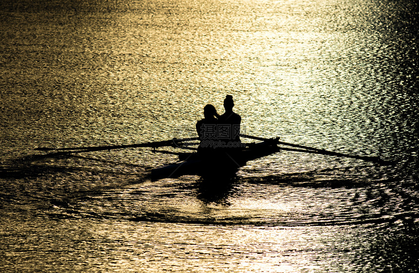 日落湖双桨中的女赛艇运动员图片