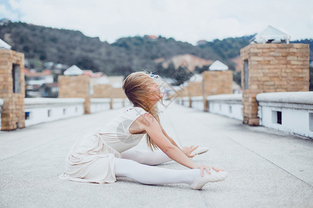 年轻美丽的女孩在码头上摆着芭蕾舞公寓和一图片