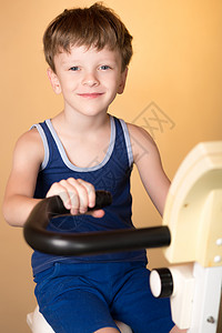 孩子在固定自行车上接受训练引领健康的生活方式男孩发展肌肉又累图片
