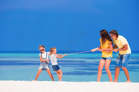 幸福的家庭一起在白色的沙滩上玩耍图片