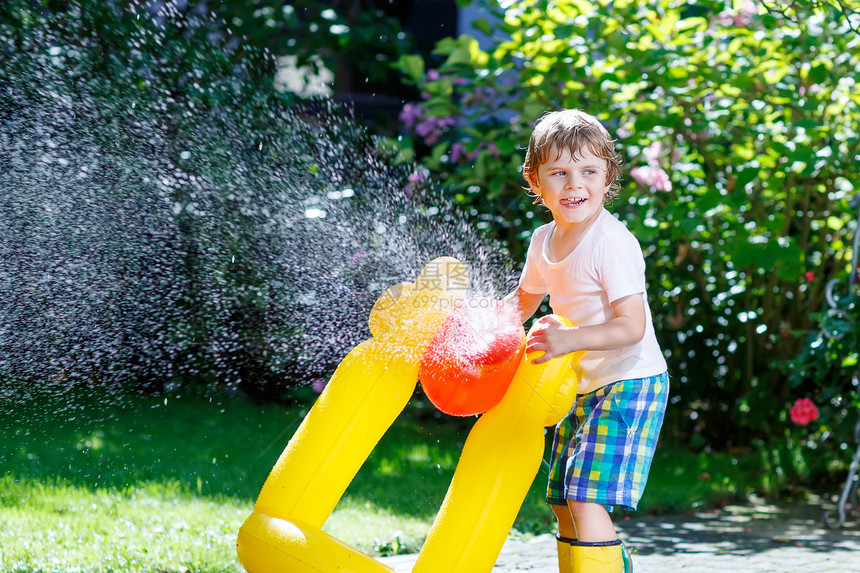可爱的小男孩在炎热和阳光明媚的夏日玩花园软管孩子在户外玩得开心孩子图片