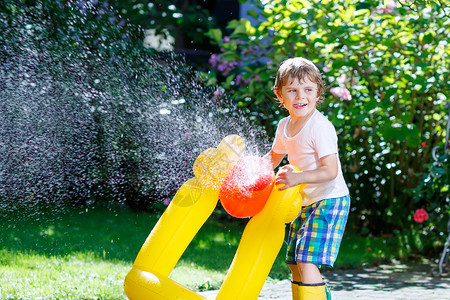 可爱的小男孩在炎热和阳光明媚的夏日玩花园软管孩子在户外玩得开心孩子图片