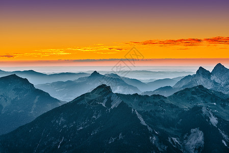 欣赏蓝色的山脉和金黄色的日落天空图片