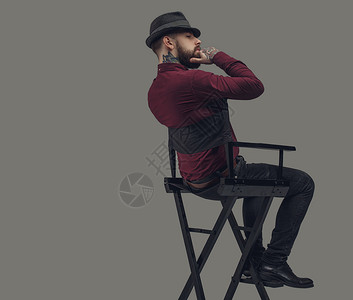 戴着帽子坐在电影导演椅子上的男人孤背景图片