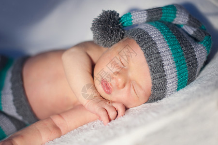 刚出生的男孩戴着针织帽睡觉高清图片