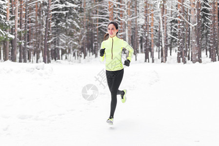 年轻女子在寒冷的冬天户外奔跑心血图片