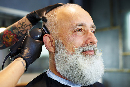 专业理发店英俊胡子男的侧面肖像理发师用图片
