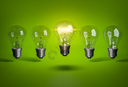 绿色背景上的一排灯泡中的一个发光灯泡图片