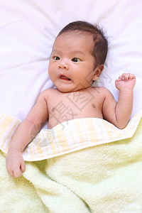 亚洲的新生婴儿在白色的床上心情愉快地放松图片