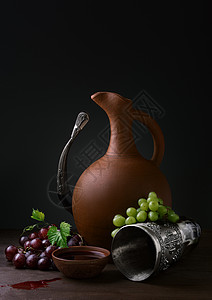 酒壶和葡萄在木制的桌图片