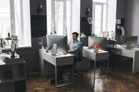 青年男子在办公室工作单位工作时从事计算机工作的图片