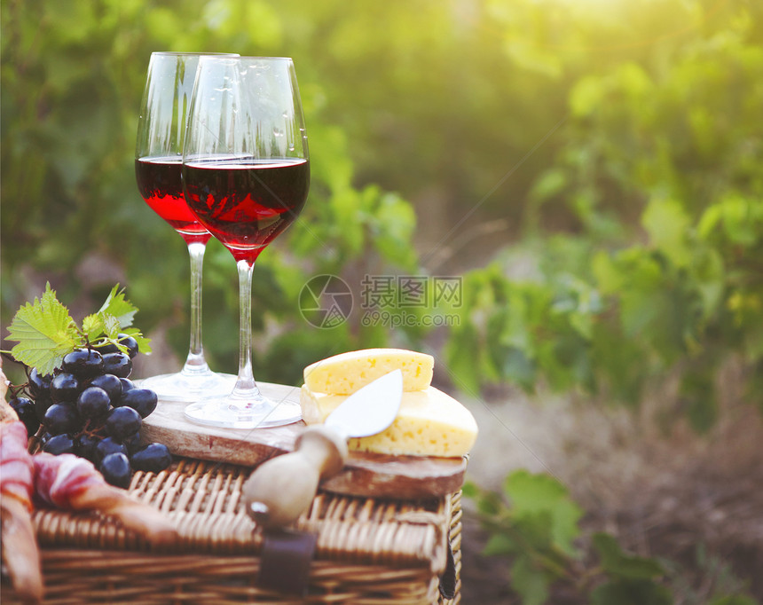 两杯红酒葡萄园背景上面有包肉图片