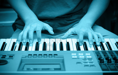 弹奏键盘或钢琴的手图片