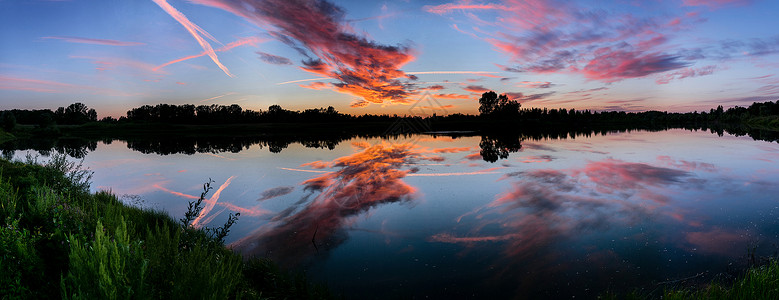 日落天空在湖水中的倒影宽全景拍摄图片
