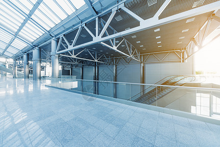 现代办公大楼或机场玻璃墙壁和反射地板自然光和照明弹的图片