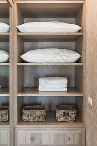 白毛巾和白色枕头放在木衣柜里图片