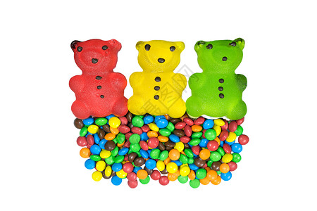 三只熊红黄绿和很多彩色糖果在白色背景背景图片