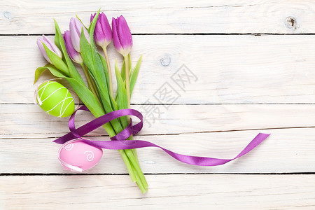 紫色的郁金香花束和东方鸡蛋白木桌图片