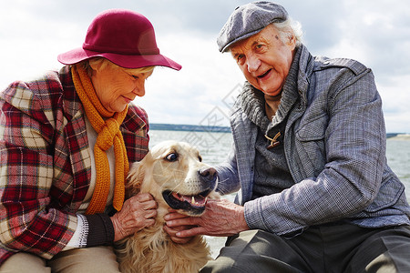 退休夫妇与狗在海边度过时光图片