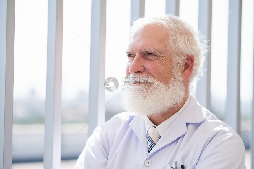 微笑着的高级医生在远处寻找室图片