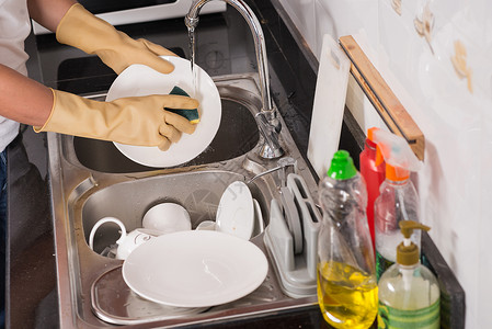 在家戴橡胶手套洗碗的人手图片