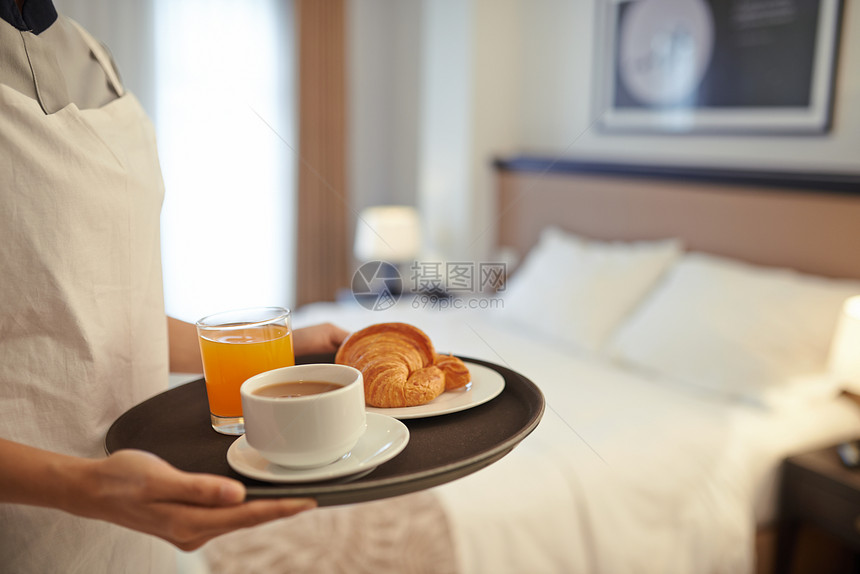 带咖啡果汁和羊角面包的托盘给在旅馆做客图片
