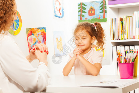 女学生闭上眼睛在课桌前与老师图片