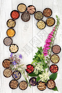 自然疗法花卉和草药选择用于草药在木碗在白色图片