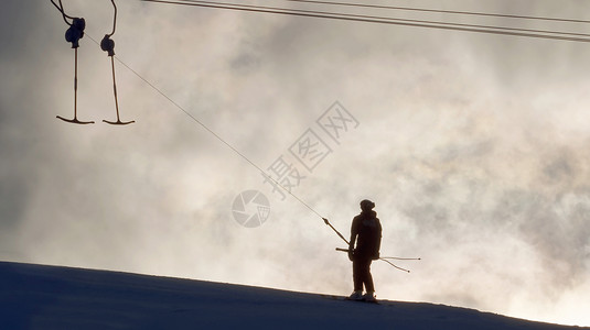 夜光下滑雪缆车和滑雪者的剪影图片