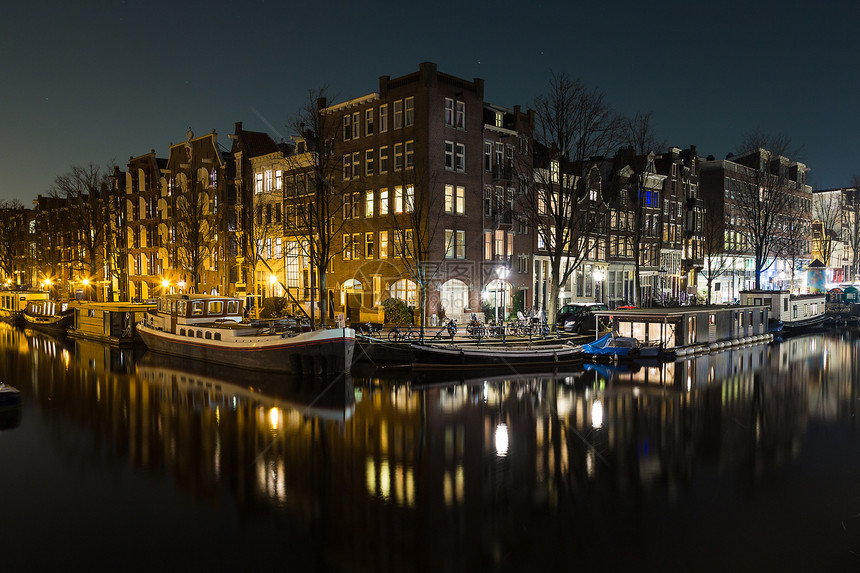 夜间阿姆斯特丹运河沿岸的建筑物和船只景观水中可以看到倒影图片