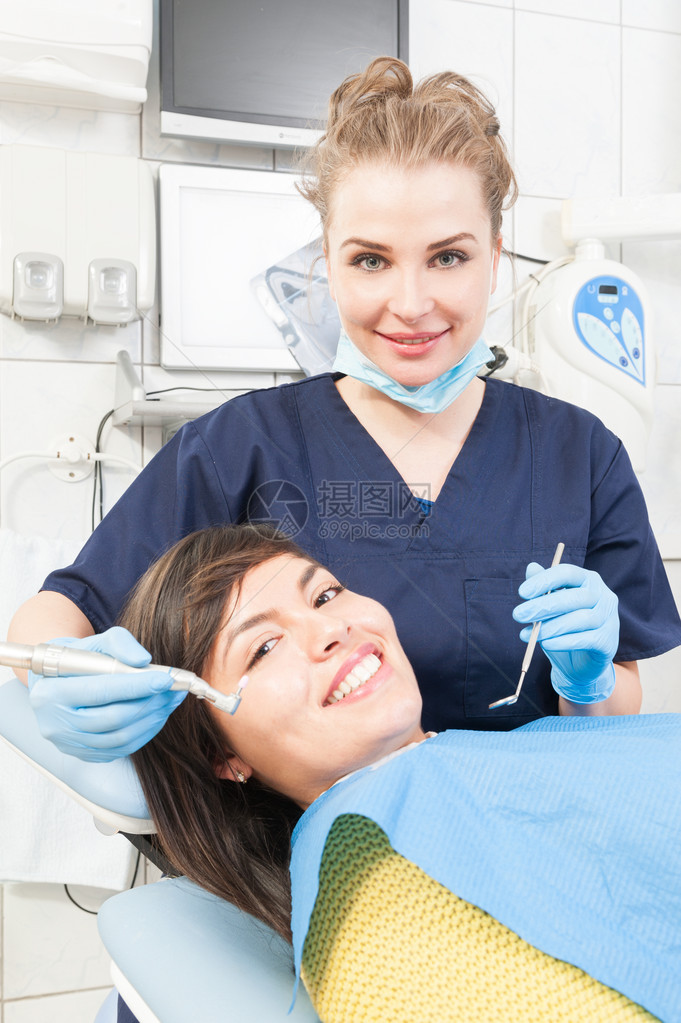 美丽的牙医正在牙科诊所使用牙科工具治疗患者的牙齿图片