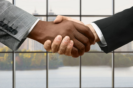 经理们在办公室握手商人在白天握手在公司总部进行交易峰会图片