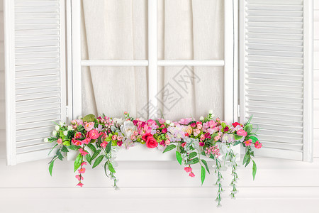 窗下盛开的花坛苗圃白色的窗户窗台上的鲜花图片