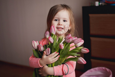 带着一束鲜花微笑的小女孩图片