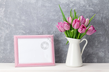 瓶中新鲜粉红色郁金香花束和空白照片框图片