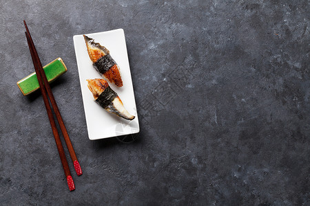 黑石桌上的一套不毛寿司和筷子带有复制图片